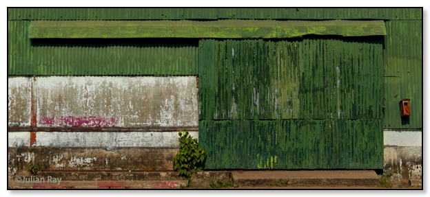 A green corrugated tin wearhous door